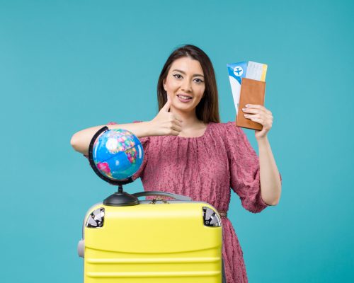 front-view-female-vacation-holding-plane-tickets-blue-desk-sea-trip-vacation-woman-voyage-journey
